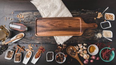 Ahşap masada çeşitli renkli otlar ve baharatlar. Baharat ve bitkilerin en üst görüntüsü. Baharatlar ve otlar ahşap masa arkasında..