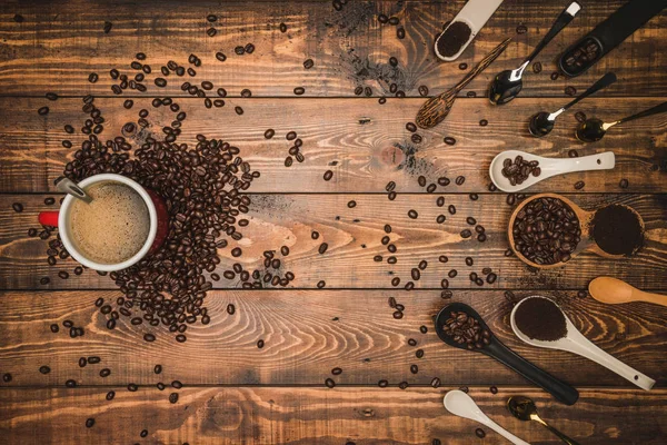 Bruna kaffebönor och en kopp varmt kaffe på ett träbord med honung. Trä bakgrund och espresso och bönor. Toppvy med kopieringsutrymme för din text. — Stockfoto