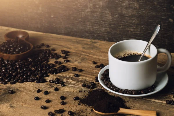 Vue de dessus Café noir chaud sur une vieille table de cuisine. concept de fond Tasse à café et grains de café avec poudre moulue sur table en bois. Café en grains sur la table . — Photo