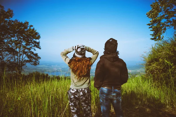 Couples travel nature. Travel relax. Standing natural touch grass on the Mountain at Khao-Kho. Travel honeymoon couple happy and enjoying a beautiful nature. travel Thailand