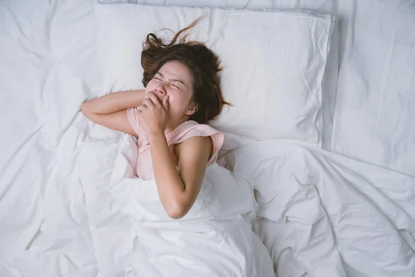 Teenager-Mädchen schläft ausgeruht. Gute Nachtruhe Konzept. Mädchen im Pyjama schläft morgens auf einem Bett in einem weißen Zimmer. warmer Ton. — Stockfoto