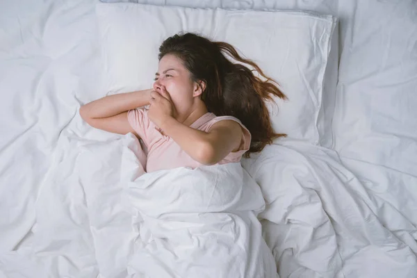 Teenager-Mädchen schläft ausgeruht. Gute Nachtruhe Konzept. Mädchen im Pyjama schläft morgens auf einem Bett in einem weißen Zimmer. warmer Ton. — Stockfoto