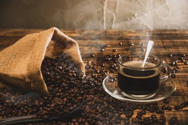 Kahve fincanı ve fasulye eski mutfak masasında. Metnin için kopyalama alanı olan üst görünüm. Kahve poşeti ve kahve çekirdekleri ahşap masada. Espresso.