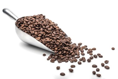Kaşık kaşık kahve kepçesi ve kahve çekirdekleri beyaz arka planda kavrulmuş ve metin için fotokopi alanı var.
