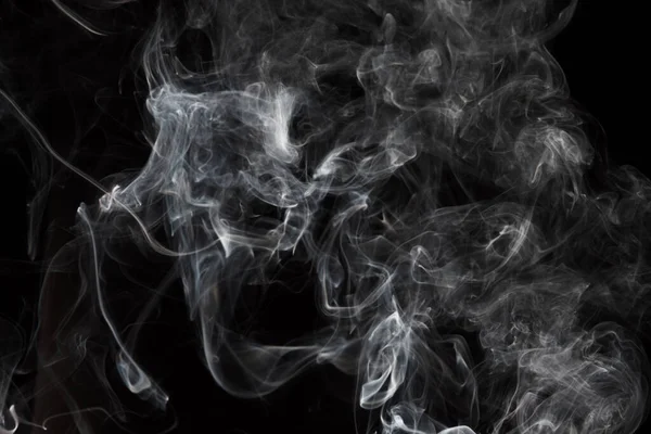 Duman siyah arkaplanda izole edildi. Beyaz dumanın hareketi