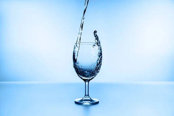 Salpicaduras Agua Vidrio Aislado Sobre Fondo Azul —  Fotos de Stock
