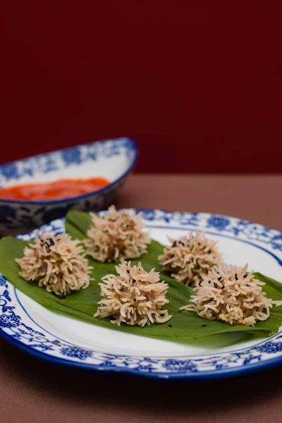Chicken flower dumplings- Chicken mince balls covered with soaked rice and steamed and served with red chilly sauce