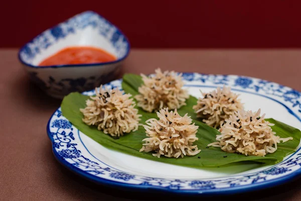 Chicken flower dumplings- Chicken mince balls covered with soaked rice and steamed and served with red chilly sauce