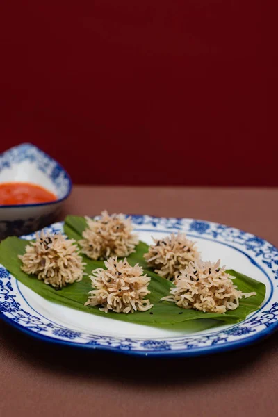 Chicken flower dumplings- Chicken mince balls covered with soaked rice and steamed and served with red chilly sauce