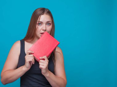 Genç güzel kadın kırmızı bir kitap onun elinde, üzerinde mavi arka plan ayakta ısırıkları; siyah bluz giyiyor. Ayrı tutma, Sol taraflı, studio, model