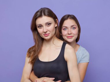 İki çekici genç kadın ayakta huging, başka bir yanında bir. Bir başka bir koyu kahverengi ile mavi gözlü esmer ikisi de. İzole, stüdyo