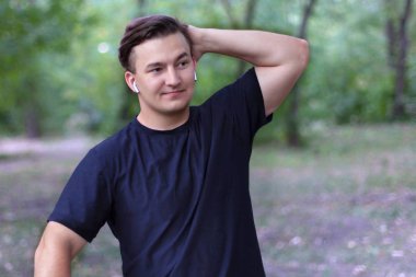 Hayal kırıklığına uğramış genç beyaz biri kafasına bir el koyar, bir şey yanlış, karmaşık pişmanlık veya üzgün ifade yüzünde gidiyor. Açık havada, alanı ise, yakın çekim. Giyim, beyaz kulaklık.