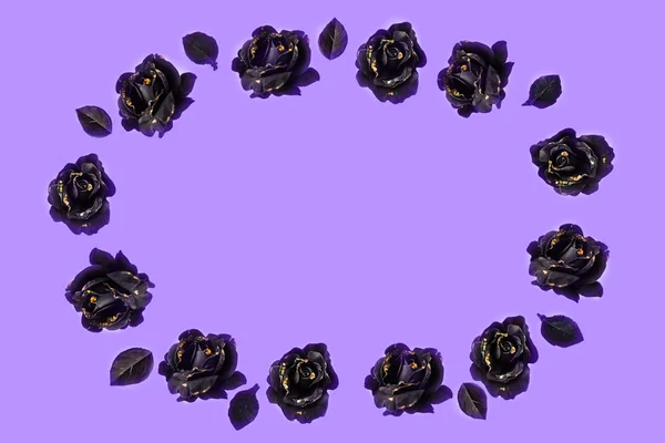 The ornament for congratulations made from black roses with black leaves on lilac background; oval shape, isolated; copy space for any text.