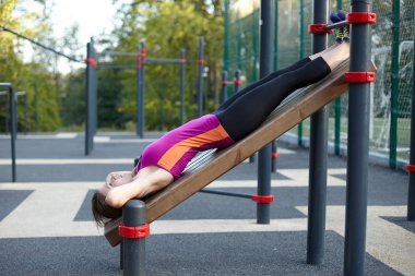 Park spor zemin genç kafkas kadın egzersiz programı. Kız karın excersise, siyah ve Lila spor yapar. Beyaz kulaklık, koruyucu eldiven. Gerçek kadın sabah eğitim. Açık, kopya alanı. 