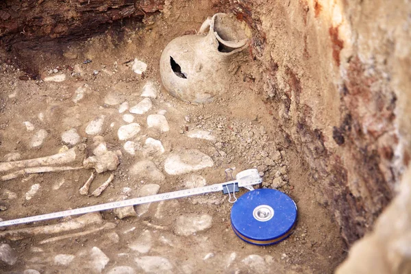 真正的考古发掘 墓穴中的人类骨骼遗迹和在地下发现的保存完好的黏土罐 复制空间 — 图库照片