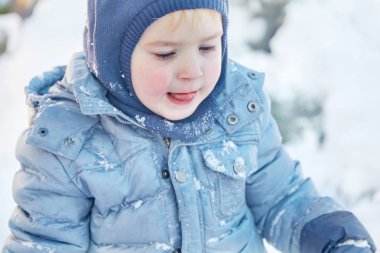 Kış giysileri ve şapka (başlık) kış, dil dışında ile parlak mavi gözlü sevimli beyaz liittle çocuk. Sağlıklı çocukluk. Açık havada, Kış etkinliği. Uzay kopyalayın, portre kadar yakın. 