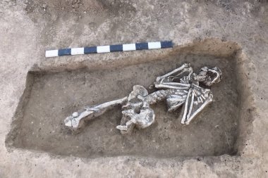 Arkeolojik kazılar. İnsan (iskelet kemikleri) ölçü tahta ile yere kalır. Gerçek kazıcı işlemi. Açık havada, kopya alanı.