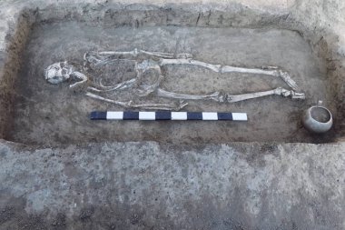 Arkeolojik kazılar. İnsan (iskelet kemikleri) ölçü tahta ile yere kalır. Gerçek kazıcı işlemi. Açık havada, kopya alanı.