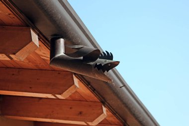 Çatı Oluk (balık şekli) metal parçası. Ahşap ev mavi gökyüzünün altında. Yapıcı açık havada ayrıntı. Kopya alanı.