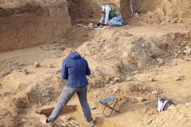 Arkeolojik kazılar. İnsan kalıntıları çizim ile insan kemikleri, mezar araştırma arkeologlar bir kazıcı işlemde. Gerçek kazıcı işlemi. Açık havada, kopya alanı.