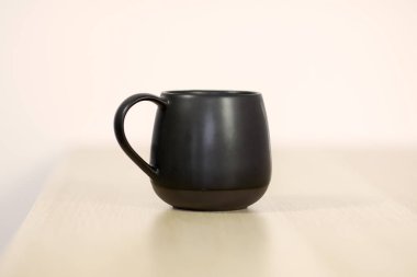 Siyah çay veya kahve kap beyaz arka plan üzerinde beyaz ahşap masa üzerinde. Uzay kopyalayın, yakın çekim. 