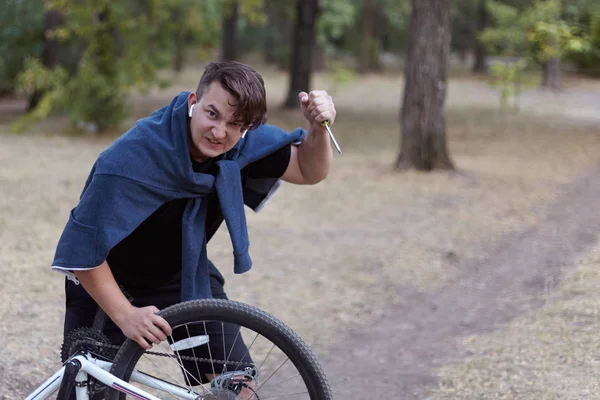 Young Causacian Man Screwdriver Tries Damage Bicycle Wire Abandoned Park — Stock Photo, Image