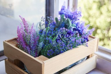 Bahar Eflatun çiçekler makro ahşap kafes pencere pervazına, leylak ve menekşe farklı tonları. Uzay kopyalayın, yakın çekim.