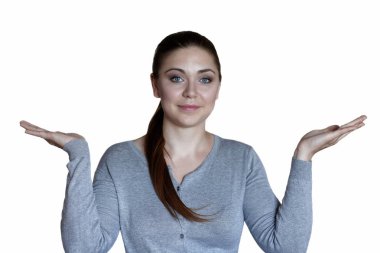 Mavi gözleri ile genç çekici beyaz kadın ve bir şey sunan avuç içi silah kaldırdı. Gülümseyen, rahat, olumlu duygular giyiyor. İç mekanlar, kopya alanı, beyaz arka planda yalıtılmış.