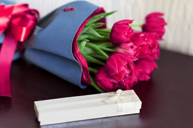 Herhangi bir metin veya mesaj için kopya alanı ile açık yeşil arka plan üzerinde bir hediye kutusu ile taze brigh pembe lale ler tasarlanmış buket.