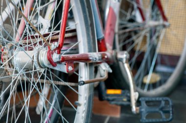 Merdivenlerin altındaki dolapta duran iki eski, tozlu bisiklet. Tekerlekleri, telleri, şanzıman zincirini ve pedalları kapatın. Boşluğu kopyala. 