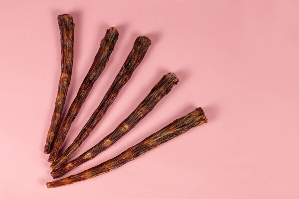 Некоторые сухие хвосты говядины на розовом фоне. Обезвоживание собак, хрустящее мясо и кости. Домашний корм для домашних животных, здоровый и натуральный. Большое пространство для копирования любого текста
.