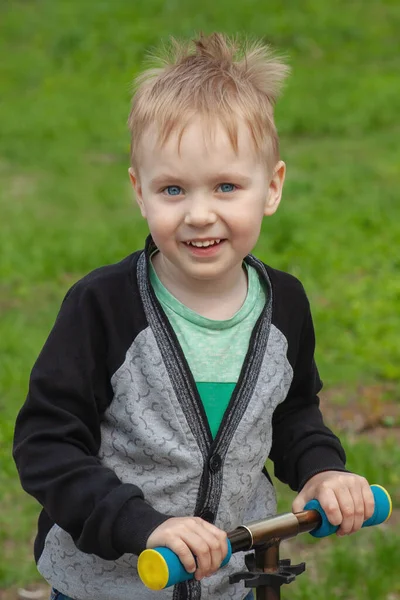 青い目のかわいいブロンドの白人の少年はキックスクーターで公園で楽しんでいます かなり笑顔の赤ちゃんの顔 肯定的な感情 積極的な時間を過ごす 幸せな子供時代 コピースペース — ストック写真
