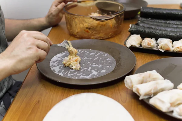 A person preparing Vietnamese spring rolls