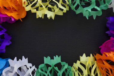 Siyah bir arka plan üzerinde renkli kağıttan çelenk