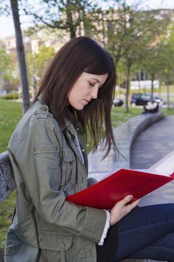 Kırmızı bir klasör tutan bir öğrenci kız