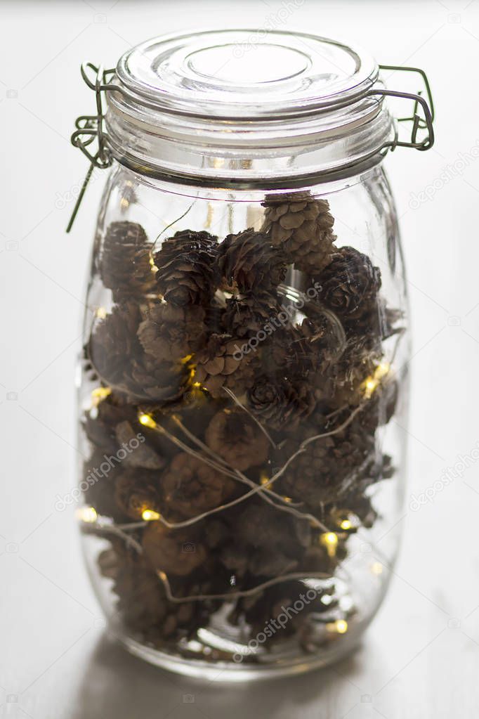 A glass jar with pinecones as ornament