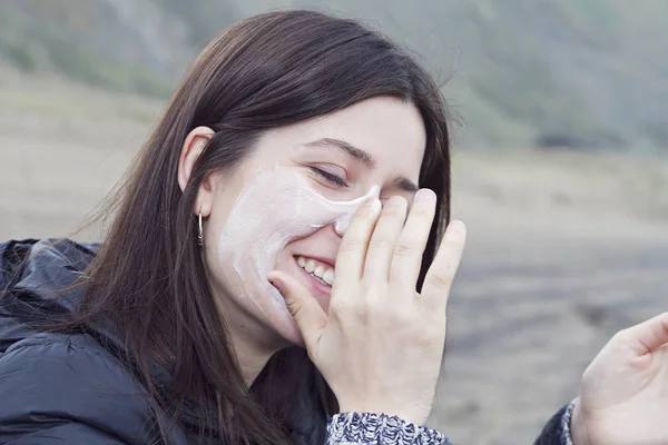 Uma Jovem Mulher Espalhando Protetor Solar Sobre Rosto — Fotografia de Stock