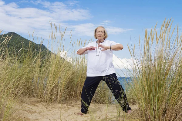 Una Mujer Mayor Practicando Tai Chi Una Playa —  Fotos de Stock