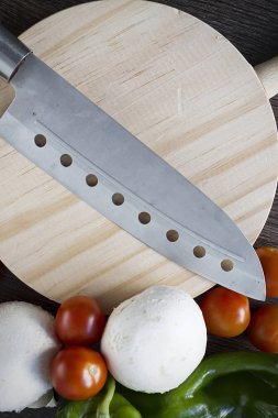 Sebze ve gıda kesmek için ahşap bir masa üzerinde profesyonel bir bıçak