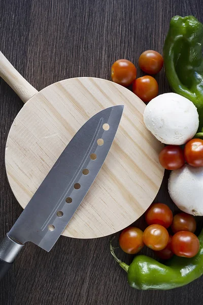 A professional knife over a wooden table to cut vegetables and food