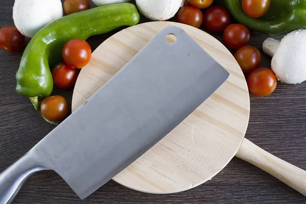 A professional knife over a wooden table to cut vegetables and food