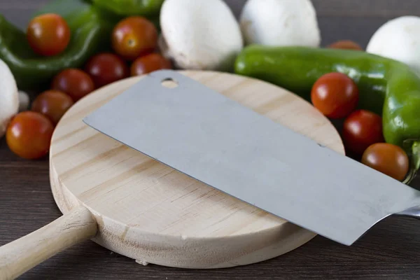 A professional knife over a wooden table to cut vegetables and food