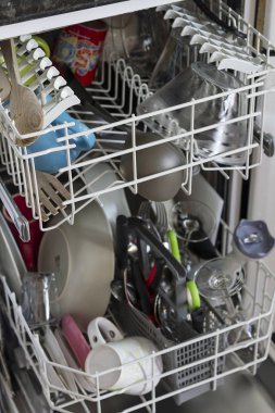 Temiz aletleri olan ince bir bulaşık makinesi.