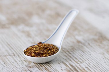 Porselen kaşıklarda baharatlar ve bitkiler.