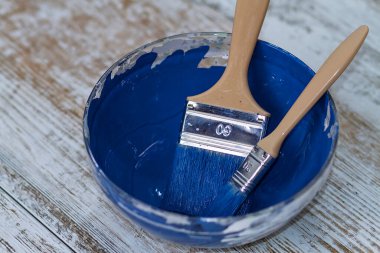 İki fırça ve bir kase ile koyu mavi tebeşir boyası