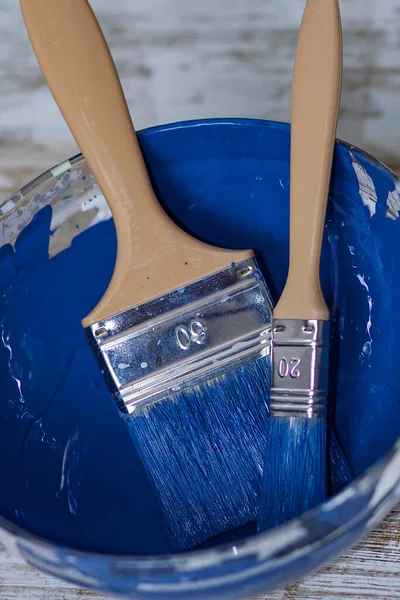 İki fırça ve bir kase ile koyu mavi tebeşir boyası