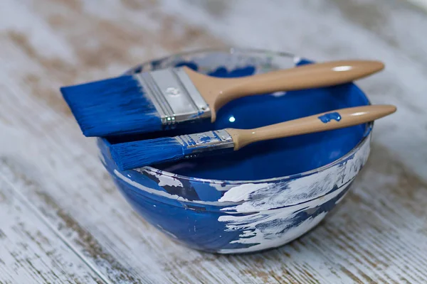 İki fırça ve bir kase ile koyu mavi tebeşir boyası