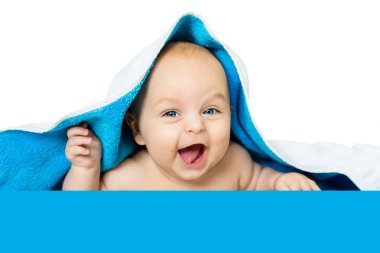 Beyaz, mavi bir havlu altında iri gözlü şirin bebek izole. Çocuk yalanlar üzerine yumuşak bir battaniye