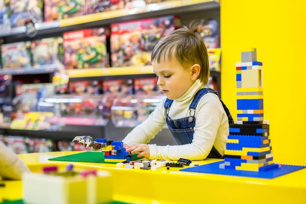 Lego, sarı bir arka plan üzerinde oynarken kardeşler.