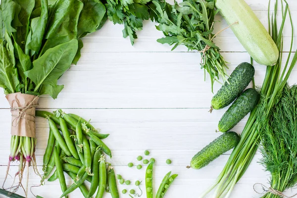 白地にグリーン有機ベジタリアン製品の組成 緑の葉野菜 ズッキーニ ニンニク 玉ねぎ きゅうり ピーマン ほうれん草 上からの眺め 緑色食品 — ストック写真